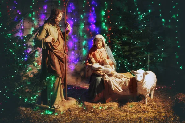 Christmas Manger scene with figures including Jesus, Mary, Joseph, sheep and magi. Christmas background