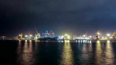 Zaman turları. Çin. İskeleye demirlemiş büyük bir nakliye gemisinin kargo operasyonu. Limanda büyük bir kargo terminali var. Mısır gevreği sevkiyatı gece yol ulaşımından gemiye. Tarım ürünleri taşımacılığı.