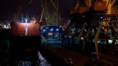 İskeleye demirlemiş büyük bir nakliye gemisinin kargo operasyonu. Limandaki büyük kargo terminali.. 