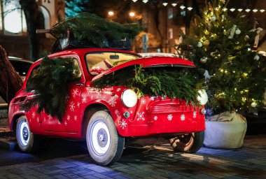 Paris 'te sokak gecesinde hediye kutularıyla kırmızı retro araba ve Noel ağacı. Noel ve Yeni Yıl sokak dekorasyonu festival ışıkları, akşamları bokeh. 
