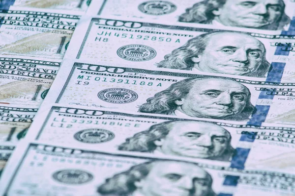 Background of one hundred dollar bills. Benjamin Franklin on USA money banknote.  American dollars banknotes background. US dollars pattern. 100 dollars. Close-up selective focus