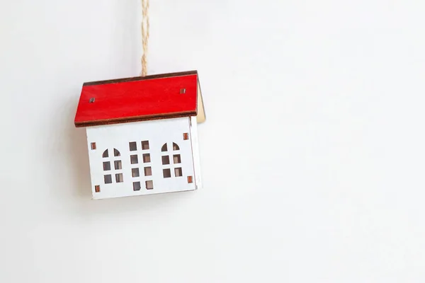 Casa de brinquedo branca em miniatura com telhado vermelho em um fundo branco. Espaço para SMS. Hipoteca, imobiliário e conceito de propriedade - close-up do modelo de casa — Fotografia de Stock