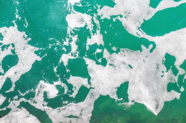 Köpüklü turkuaz deniz suyu. Soyut deniz arka planı. Okyanus dalgaları yaklaşıyor. Yumuşak odak.