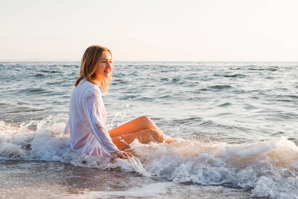 Chica Rubia Mojada Camisa Blanca Sentada Agua Playa Del Mar —  Fotos de Stock