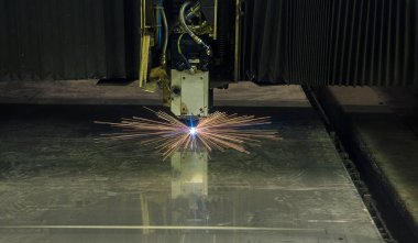 Endüstriyel lazer, düz metal levha ve kıvılcımlar üreten üretim teknolojisini kesiyor.