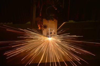 Endüstriyel lazer, düz metal levha ve kıvılcımlar üreten üretim teknolojisini kesiyor.