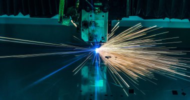 Endüstriyel lazer, düz metal levha ve kıvılcımlar üreten üretim teknolojisini kesiyor.