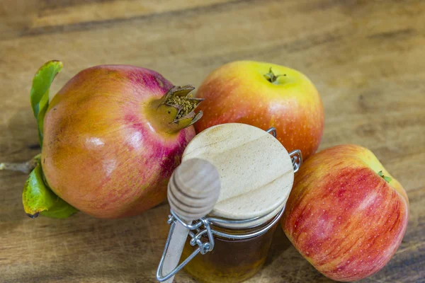 Мед, яблоки и гранаты на деревянной палубе для празднования Рош ха-Шана . — стоковое фото