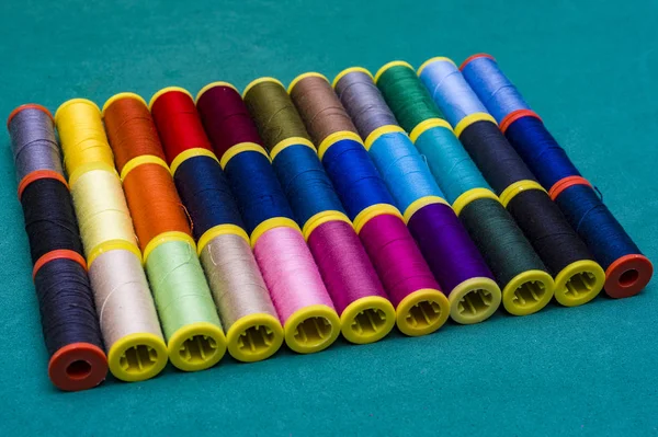 Linhas de costura multicoloridas em fundo de madeira — Fotografia de Stock