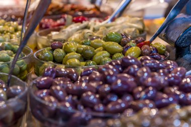 Siyah zeytin, yeşil zeytin biber ile doldurulmuş zeytin, zeytin ağacı dalları ve dağınık biberli mısır. .