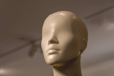 Mağaza arka planında beyaz bir mankenin başı.