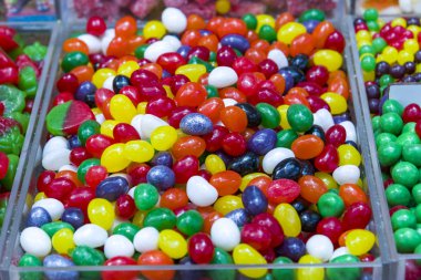 Şekerle kaplı renkli, parlak, çiğnenmiş şekerler. Gökkuşağı kurdele şekerlemeleri. Renkli jöle şekerleri parlak bir arka plan olarak kapanıyor. Üst Manzara. Şeker arkaplanı.