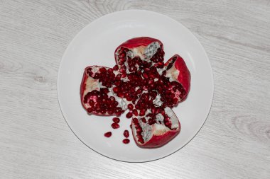 Nar dilimleri ve tohumlar gümüş üzerinde dilimlenmiş nar beyaz zemin üzerinde.