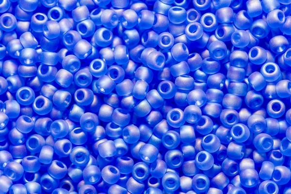 Background of baby blue glass cane beads. Blue turquoise cyan beads small beads background.