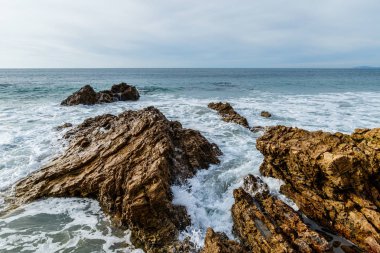 Yükselen sörf kayalık California kıyısında kırma