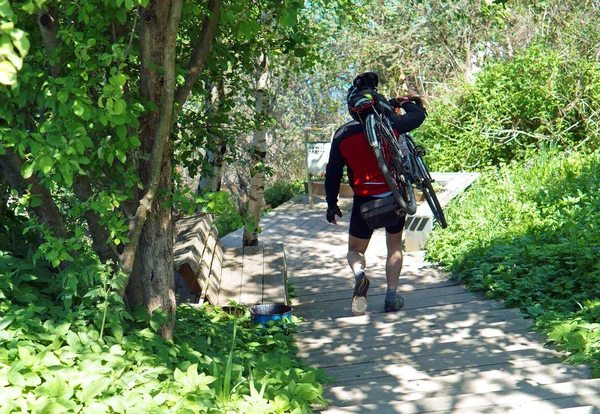 a man carries a Bicycle on his shoulder