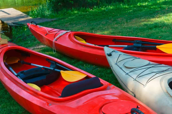 Boats at the dock, red kayaks on the shore — Stock Photo, Image