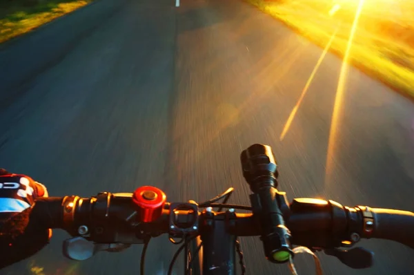 Fietstocht in de zomeravond bij zonsondergang, een wiel van een fiets in beweging closeup — Stockfoto