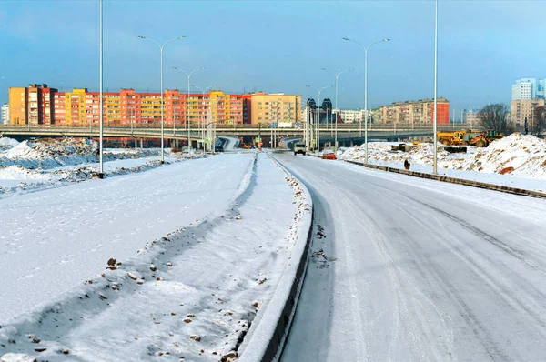 Estrada coberta de neve para a cidade, passagem de junção rodoviária e alta-r — Fotografia de Stock
