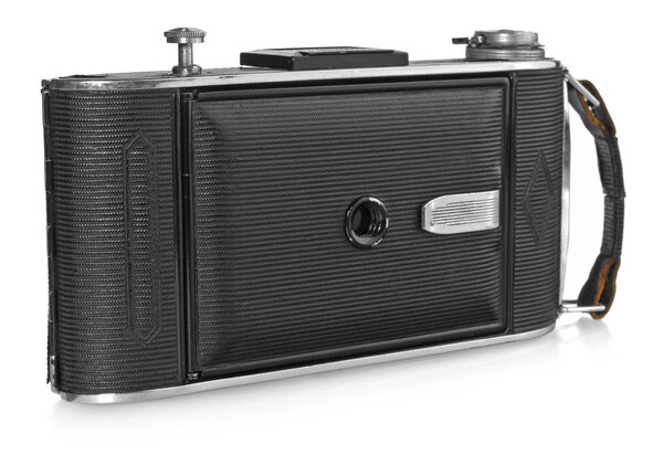 Old, antique pocket camera. Black camera closed with a black leather handle. View from the front of a white background with slight reflection. Camera model Agfa Billy Record.