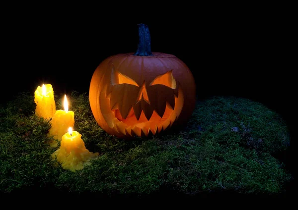 Calabaza de Halloween y velas brillando en la oscuridad en un bosque mo — Foto de Stock