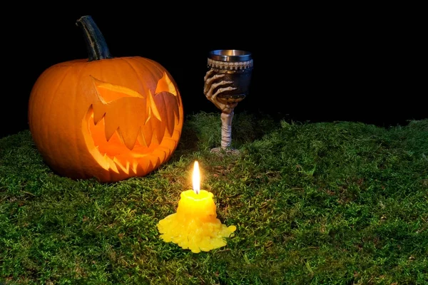 Zucca di Halloween, calice e candele che brillano al buio su un f — Foto Stock