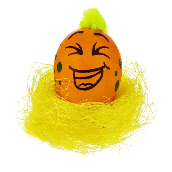 Ovo de Páscoa, feito à mão pintado em um rosto de desenho animado sorridente, sente-se em um — Fotografia de Stock