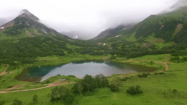 Volando sobre el lago. Montañas en la niebla — Vídeos de Stock