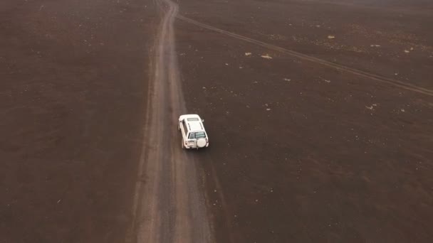 Avonturen op de Suv. De weg door de vulkaan. Jeep rijdt via de lava. Luchtfoto — Stockvideo