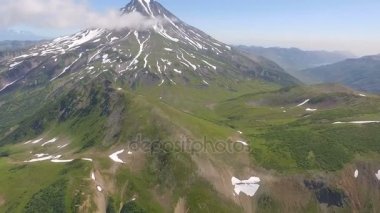 Volkan kadar alttan görüntüleyin. Kar ve çim yakın donmuş nehir