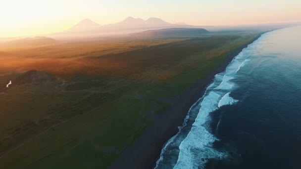 Hubschrauber fliegen bei Sonnenuntergang über das Meer in die Berge. flog das Meer bei Sonnenaufgang. Nebelberge — Stockvideo