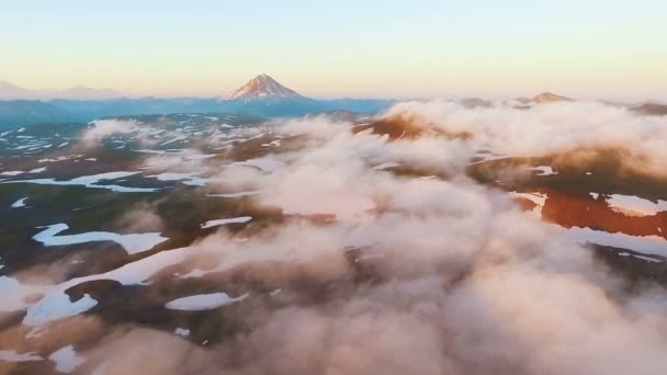 Vista aérea. O avião voa através das nuvens. Uma vista incrível. Montanha durante o pôr do sol — Vídeo de Stock