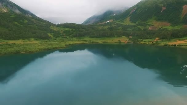 Reflections of the mountain in a lake. Beautiful turquoise lake and through the green forest — Stock Video