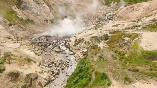 Vista aérea. A mola térmica jorra do chão. Água termal nas montanhas — Vídeo de Stock