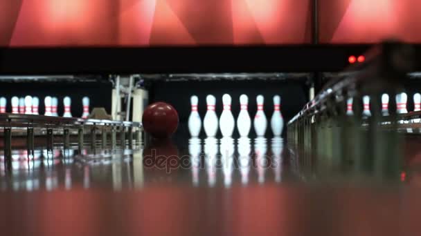 Der Ball bricht Kegelnadeln. Mann spielt Bowling in Zeitlupe. Der junge Mann schlägt zu. — Stockvideo