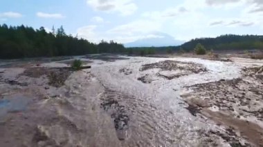 Havadan görünümü. Bulanık nehir dağlarda. Yolun su ile yıkandı