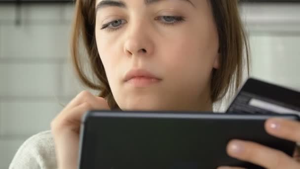 Young woman doing online shopping on tablet at home. woman using tablet computer touchscreen in cafe — Stock Video