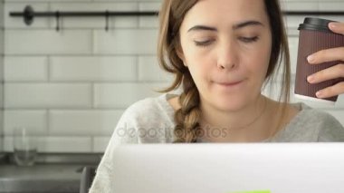 Kız bir laptop için çalışır. Yazar yazıyor metin ve kahve içiyor. Bir kadın bir dizüstü bilgisayar çalışıyor