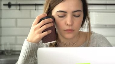 Kız bir laptop için çalışır. Yazar yazıyor metin ve kahve içiyor. Bir kadın bir dizüstü bilgisayar çalışıyor