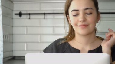 Kız kameraya bakıyor ve gülümsüyor. Kız bir smartphone üzerinde konuşmak ve bir dizüstü bilgisayar üzerinde çalışan