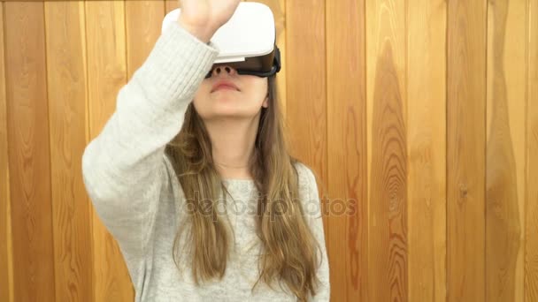 A mulher usa óculos de realidade virtual. Mulher jovem em óculos de realidade virtual. mulher jogando jogo VR — Vídeo de Stock