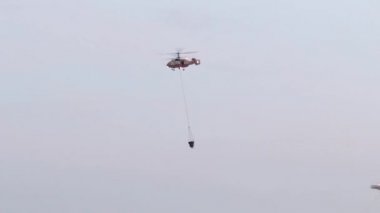 Helikopter damla su köknar. Bir helikopter su galon yüzlerce alevler üzerinde bırakarak kuru bir dağın üzerinde dev bir orman yangını savaşları. Askeri helikopter. Acil durum