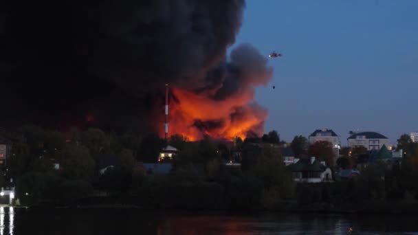 火災や都市で爆発。救助ヘリコプター消火の生命を危険にさらします。消防ヘリコプターは、煙のパフに飛ぶ。火災消火の水と空気中から — ストック動画