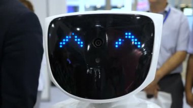 Robot kamera ve gülümsüyor görünüyor. Modern robotik teknolojiler. Robot kişi kameraya bakar. Robot duygular gösterir. Onun ellerini, dansları yükseltir veya kızgın