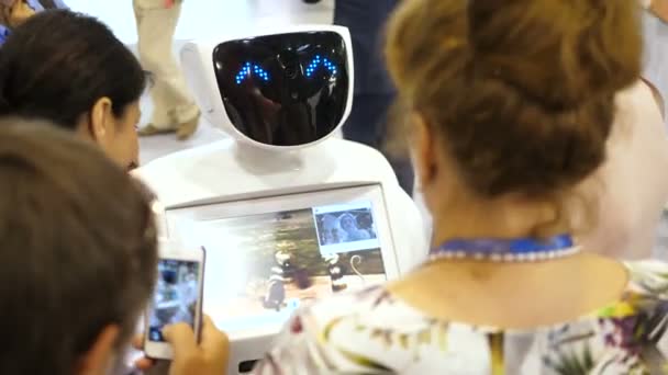 Новосибирск Россия - 29 июня 2017: Робот общается с людьми на выставках. Робот с интерактивным дисплеем общается с посетителями в бизнес-центре. Люди с его сенсорным экраном — стоковое видео