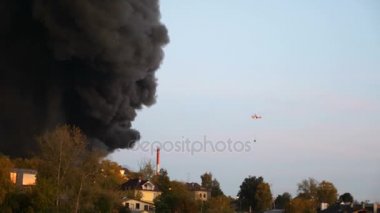 Helikopter şehir yangın söndürme. Helikopter ateş ve duman uçar. duman ve alevler. İtfaiyeciler bir ekip tutun. Hortum ve bir ev yangını söndürdü. İtfaiyeciler yangınla mücadele