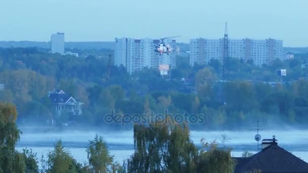 这架直升机收集水在河里去灭火。救援和消防队员将大火扑灭。直升机在空中盘旋。火在莫斯科举行。军用直升机 — 图库视频影像