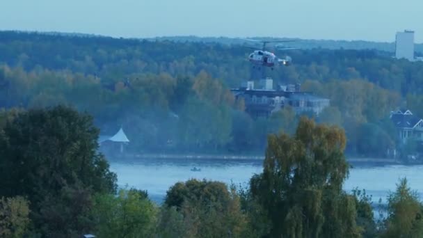 Вертолет собирает воду в реке, чтобы потушить пожар. Спасательная служба и пожарные тушат пожар. Вертолет завис в воздухе. Пожар в Москве, Россия. Военный вертолет — стоковое видео