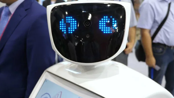 Робот смотрит в камеру и удивляется. Современные роботизированные технологии. Робот смотрит в камеру на человека. При этом Лицензионные Стоковые Изображения