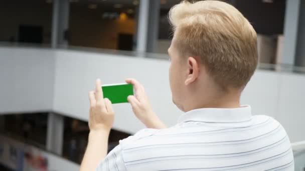 Jeune adolescent jouant au jeu sur smartphone dans un café. Jeune homme heureux jouant à des jeux sur smartphone. Smartphone s'allume sur fond blanc. Écran vert personnalisable facile. Image générée par ordinateur . — Video